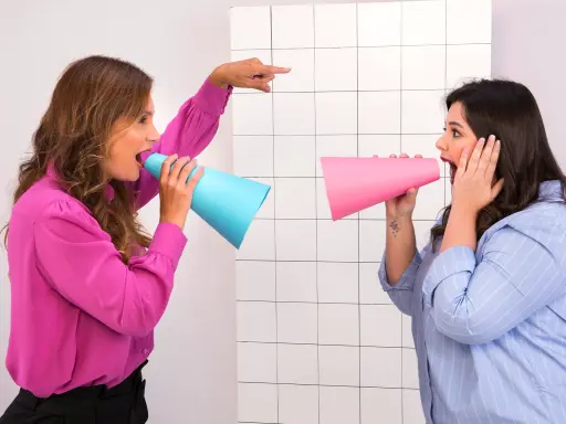 Imagem de duas mulheres falando em um megafone improvisado.