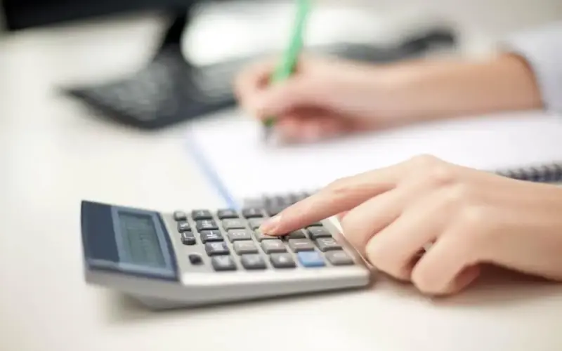 Imagem de uma pessoa fazendo um cálculo em uma calculadora