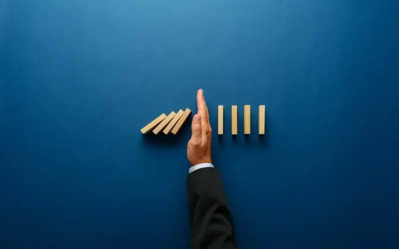 Imagem de uma mão fazendo a divisão de bloquinhos de madeira, representando uma gestão financeira