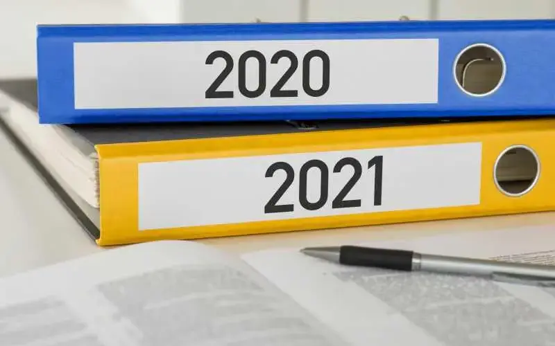 Imagem de uma pasta com a etiqueta 2020 em cima de uma pasta com a etiqueta 2021, representando as mudanças de legislação com o passar do ano
