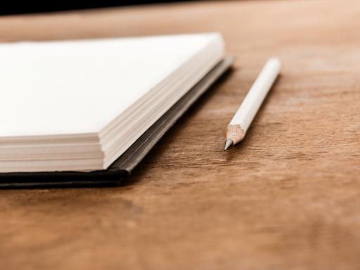 Imagem de um caderno e um lápis